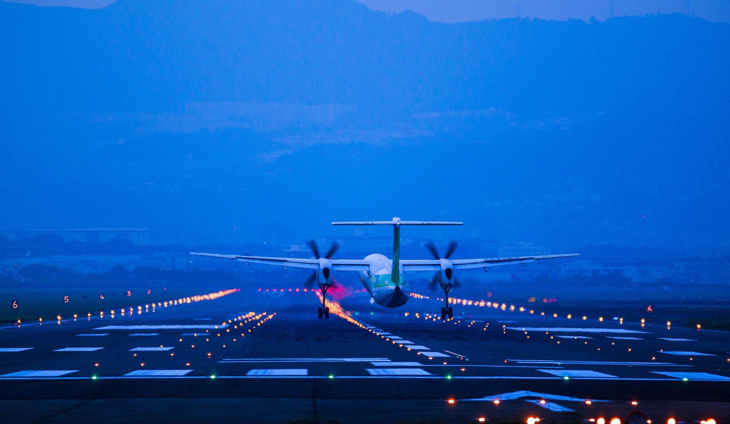 airplane taking off from runway at dusk