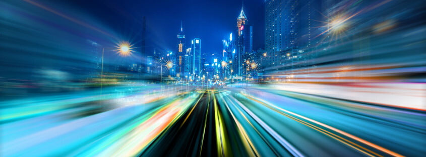 Vehicles speeding by on a downtown city road